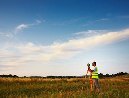 Land surveyor working with total-station. A lot of copy space.