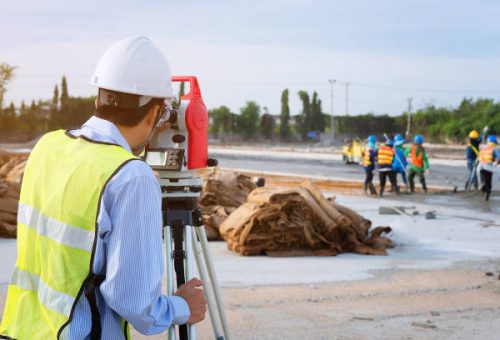 Surveyor engineers using an altometer at Construction Site.